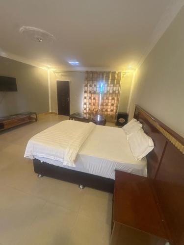 a bedroom with a large bed with white sheets at Sefitel in Lubumbashi