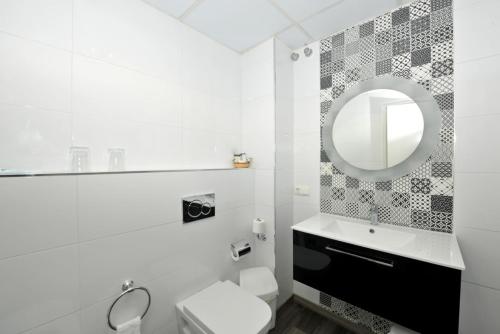 a white bathroom with a sink and a mirror at Hotel Salobreña Suites in Salobreña