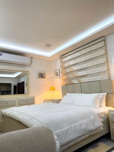 a bedroom with a large white bed and a television at Cozy Private Room with Kitchen & Private Bathroom 12 in Abu Dhabi