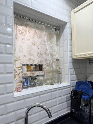 a kitchen sink with two bottles on a shelf at Cozy Private Room with Kitchen & Private Bathroom 12 in Abu Dhabi