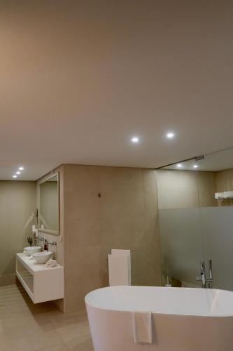 ein Badezimmer mit Badewanne, Waschbecken und Spiegel in der Unterkunft Hotel Suave Mar in Esposende