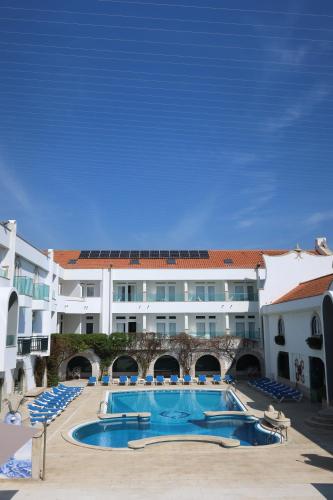 a pool in front of a large building at Hotel Suave Mar in Esposende