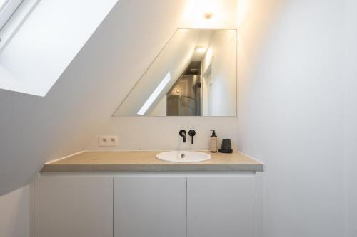 a bathroom with a sink and a mirror at Calm, Light-Filled Apartment with Private Balcony in Knokke-Heist