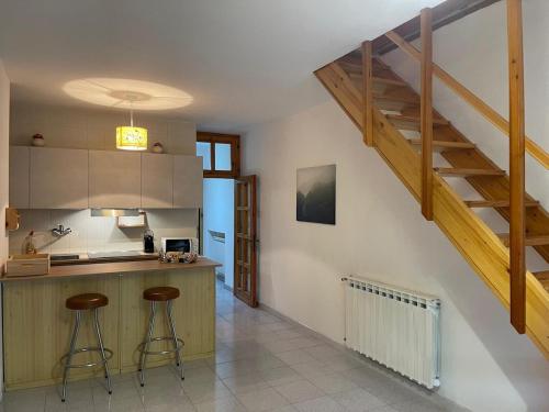 a kitchen with two bar stools and a staircase at LHE Terrazza Alba in Bagno di Romagna