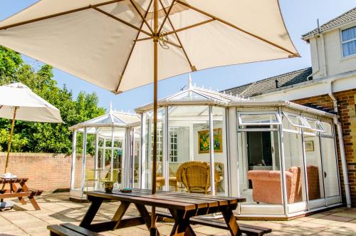 a greenhouse with an umbrella on a patio at The Avenue in Shanklin