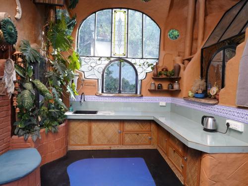 a kitchen with a sink and two windows at Taiga Forest Mountain Tree house in Wayanad