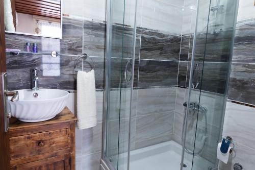 a bathroom with a glass shower and a sink at Lal Hotel Bursa in Bursa