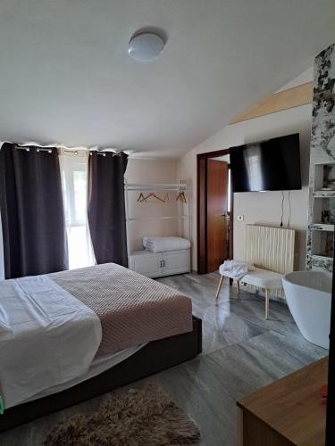 a bedroom with a bed and a tub and a sink at Hotel-Ristorante KerMes in Boccaleone