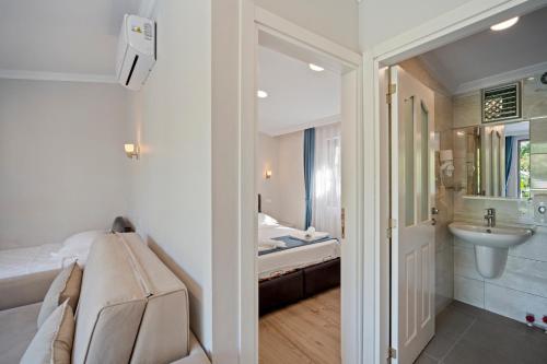 a bathroom with a bed and a sink and a toilet at KIYI SUITES OTEL Palamutbükü in Yakaköy