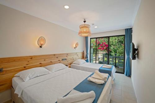a bedroom with two beds and a window at KIYI SUITES OTEL Palamutbükü in Yakaköy