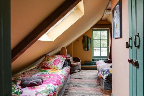a attic room with two couches and a window at BoHo Experience Wellness, Jacuzzi, Sauna, BBQ, Garden, Sleeps 10 in Kockengen