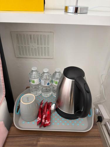 a tea kettle and cups on a tray in a refrigerator at Double bed room like a hotel room with share toilet in Hyde