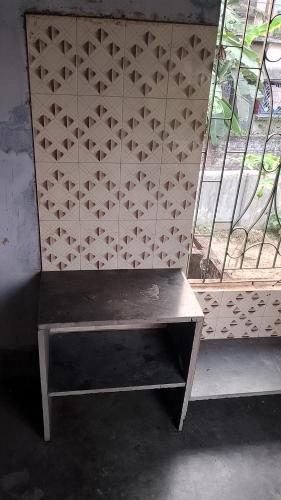 a bench sitting in front of a window at o ARYABHATTA o in Bāndel