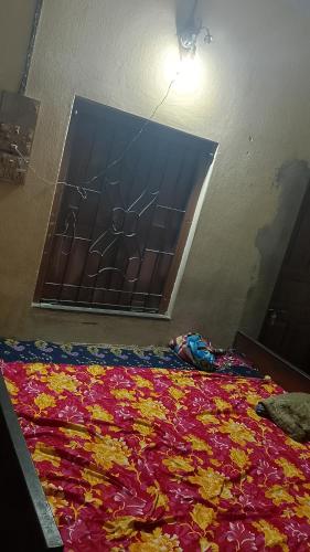 a window with a colorful blanket on a bed at o ARYABHATTA o in Bāndel