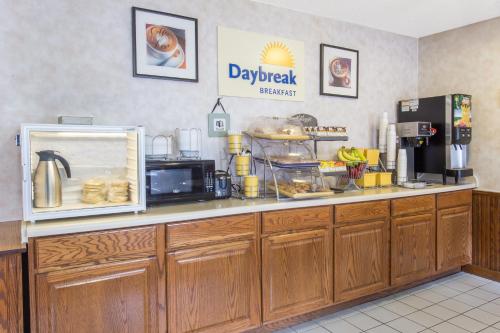 a kitchen with a counter top with a microwave at Days Inn & Suites by Wyndham Davenport East in Davenport