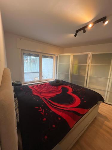 a bedroom with a bed with a red and black blanket at Always luxury for a luxurious life in Grimbergen