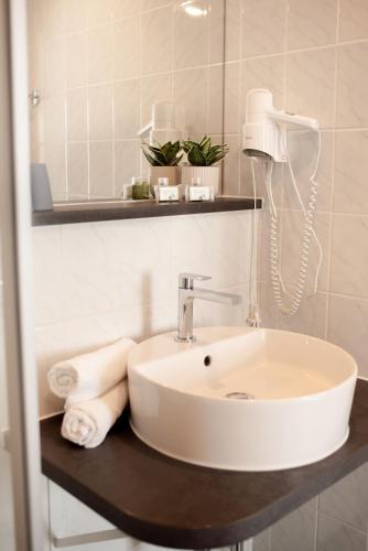 a bathroom with a sink and a phone on a counter at Hotel Roß in Zwönitz