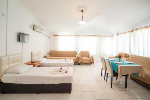 a room with two beds and a table and a couch at Side Orientt Apartments in Side