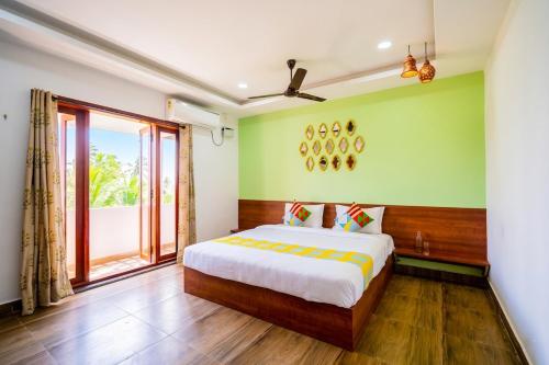 a bedroom with a bed and a large window at Signature Grande with swimming pool pondicherry in Pondicherry