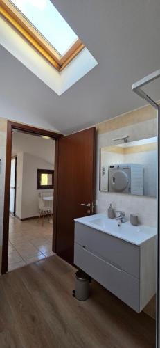 a bathroom with a white sink and a skylight at Mars' apartment in Cavalcaselle