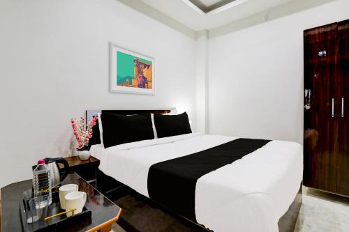 a bedroom with a large white bed and a table at Hotel O BGPG House in Varanasi