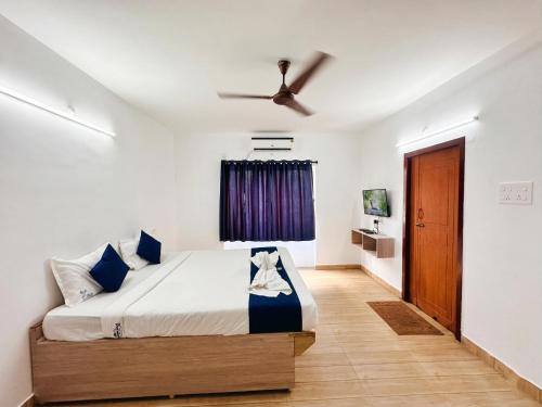a bedroom with a bed and a ceiling fan at SS Grand with swimming pool in Pondicherry