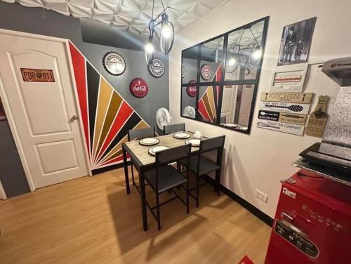 a dining room with a table and chairs and a wall with clocks at Retro Themed Condominium Staycation in Marilao