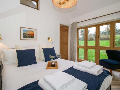 a bedroom with a large bed with a blue chair at The Blacksmiths Shop in Bromyard