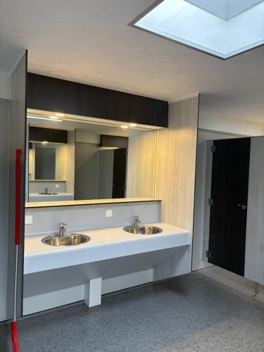 a public bathroom with two sinks and a mirror at Het Roodborstje in Holten