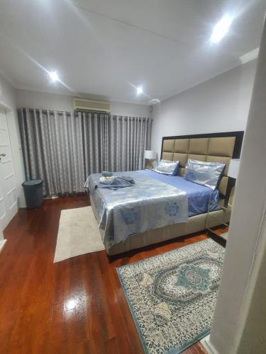 a bedroom with a bed with blue sheets and a rug at Peaceful Corner Stay in Durban
