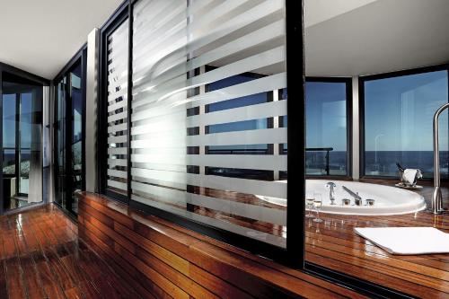 a bathroom with a tub and large windows at Paloma Sencia in Belek