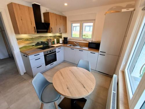 a kitchen with a wooden table and chairs in it at Landhaus de Bel in Hergenrath