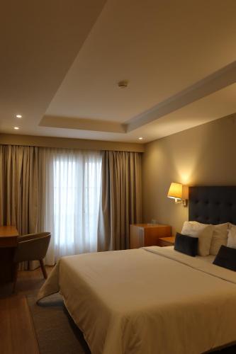 ein Hotelzimmer mit einem großen Bett und einem Fenster in der Unterkunft Hotel Suave Mar in Esposende