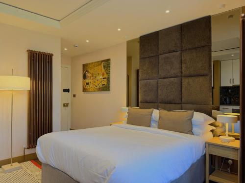 a bedroom with a large white bed and two lamps at Melbury Rooms & Studios in Exeter