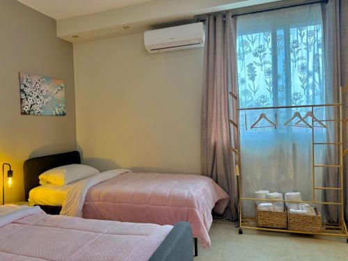 a bedroom with two beds and a window at Sunny apartment 1 in Serres