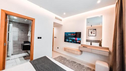 a bedroom with a bed and a television on a wall at Royal Home in Abu Dhabi