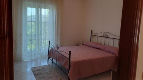 a bedroom with a bed and a large window at Casa vacanze Sisters in Vatolla