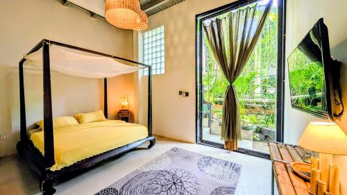 a bedroom with a canopy bed and a large window at Cargo Remote Mui Ne in Phan Thiet
