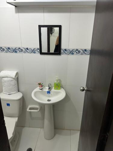 a bathroom with a sink and a toilet and a mirror at Edificio Don Ramon in Valledupar