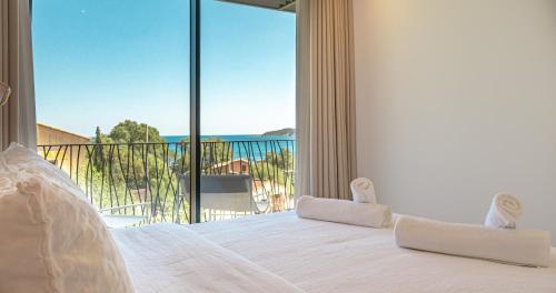 a bedroom with a bed with a view of the ocean at CADIAMARE in Zonza