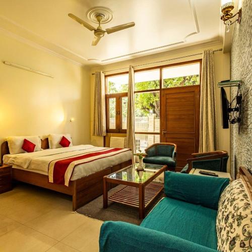 a bedroom with a bed and a couch and a table at Theap Hospitality Enterprises in Noida