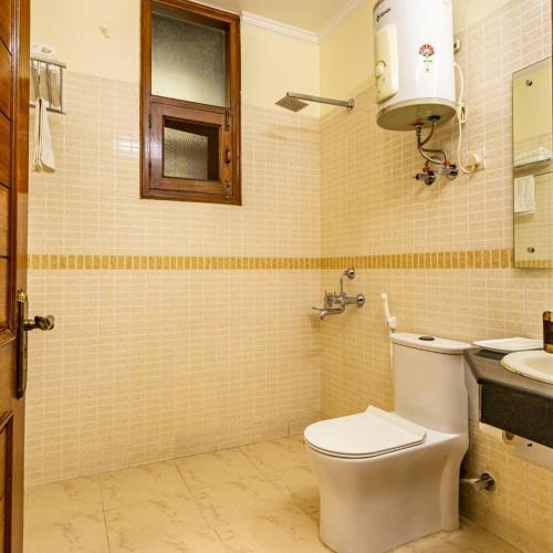 a bathroom with a toilet and a sink at Theap Hospitality Enterprises in Noida