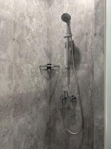 a shower with a glass door with a shower head at Graf Hotel in Shymkent