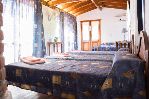 two beds sitting in a room with curtains at Estancia Santa Leocadia in Bialet Massé