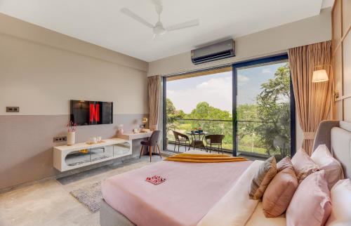 a bedroom with a large bed and a large window at Saffron Stays Augustus in Karjat