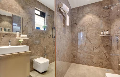 a bathroom with a shower and a toilet and a sink at Saffron Stays Augustus in Karjat