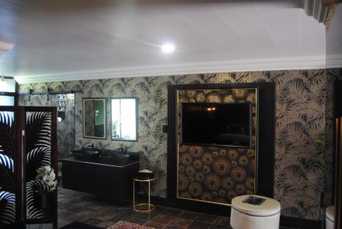 a bathroom with a sink and a tv on a wall at Villa Grande Luxury accommodation in Welkom
