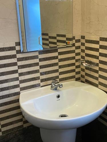 a white sink in a bathroom with a mirror at Ivery guest house in Pattipola