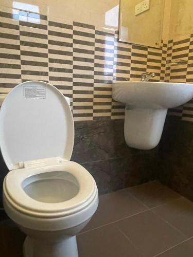 a bathroom with a white toilet and a sink at Ivery guest house in Pattipola