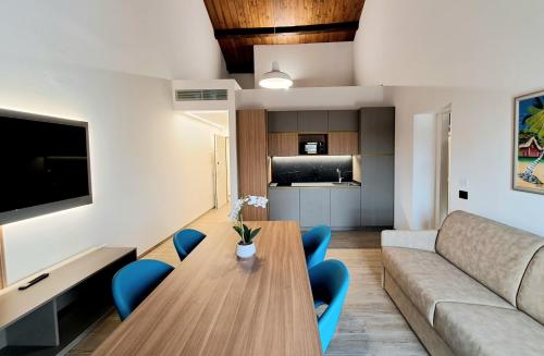 a living room with a wooden table and blue chairs at Antica Jesolo - M Factory in Jesolo